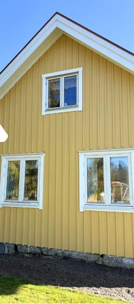Gul träfasad med återfått ljusare kulör efter rengöring