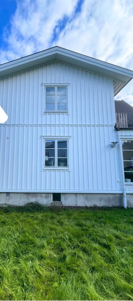 Samma vita tvåvåningsfasad ren och jämn efter fasadtvätt